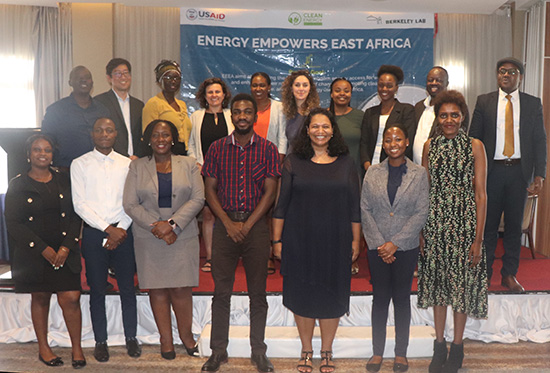 A group of 17 people pose in front of a banner with the words "Energy Empowers East Africa".