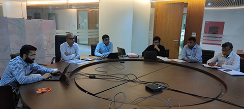 Prateek Joshi, from NREL, and partners from Bangladesh, are gathered around a conference table.