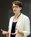 Ellen Morris speaks in front of a chalkboard