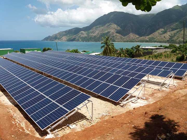 A mini-grid in Tiburon, Haiti, with the sea and mountains in the background.
