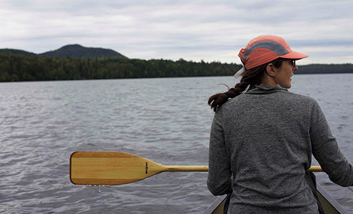 A woman in a canoe with a paddle.