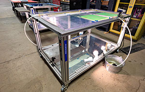 A metal-framed table with glass sides and tops.
