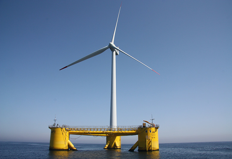 A wind turbine on a yellow, triangular frame floats on the ocean.
