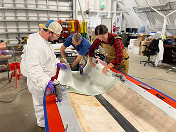 Three researchers construct a wind turbine blade using a recyclable resin.