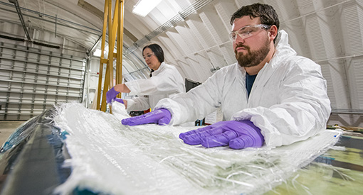 Two researchers working on wind turbine blades at NREL.