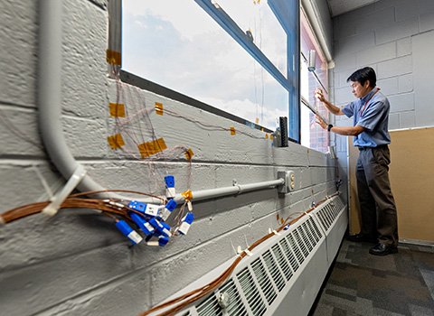 NREL engineer tests new window technology in federal agency building.