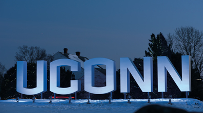 Giant illuminated letters spelling out UCONN on a snowy landscape.