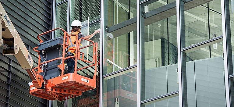 A worker applying window patterns in a building.