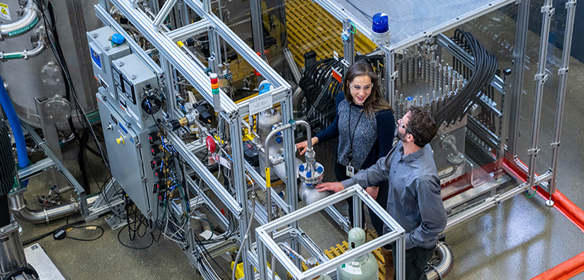 user-access-74281 Two researchers looking at mechanical equipment in the ESIF.