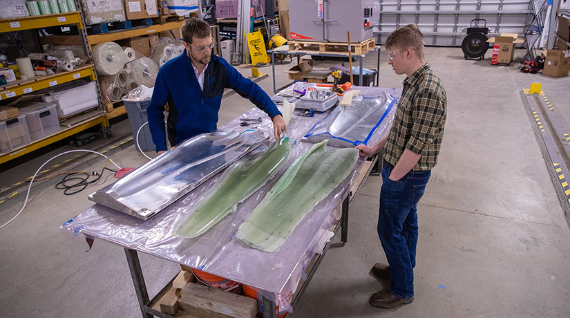 Two researchers examine turbine tidal blade skins.