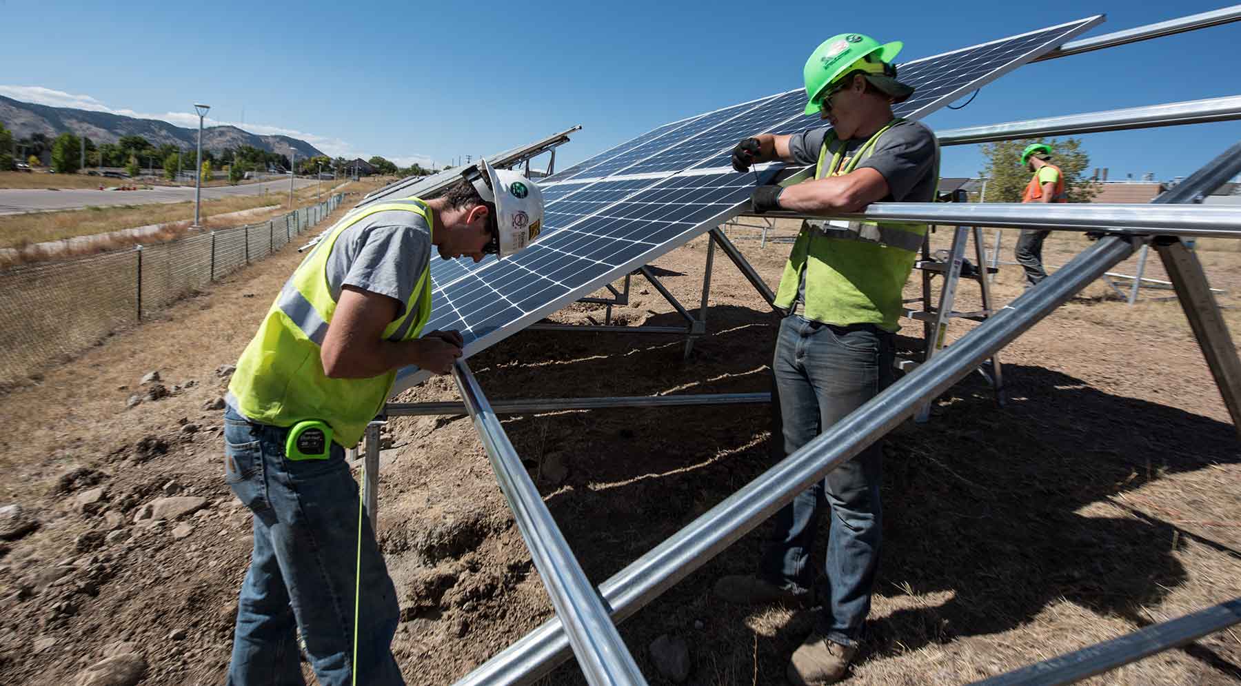 Workers install PV modules at NREL's new solar array field.