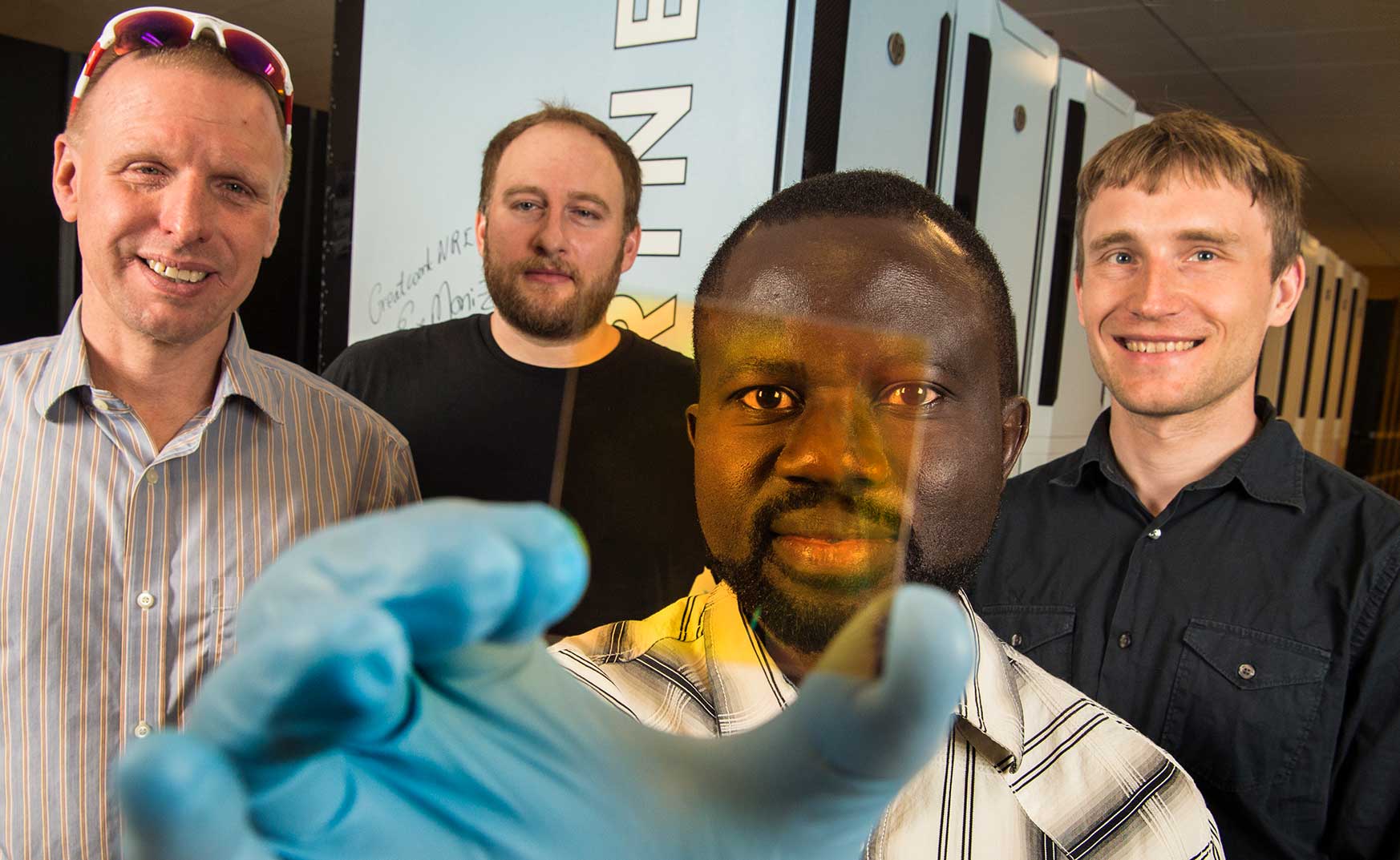 NREL team holds up new alloy sample that may become part of the next-generation semiconductors.