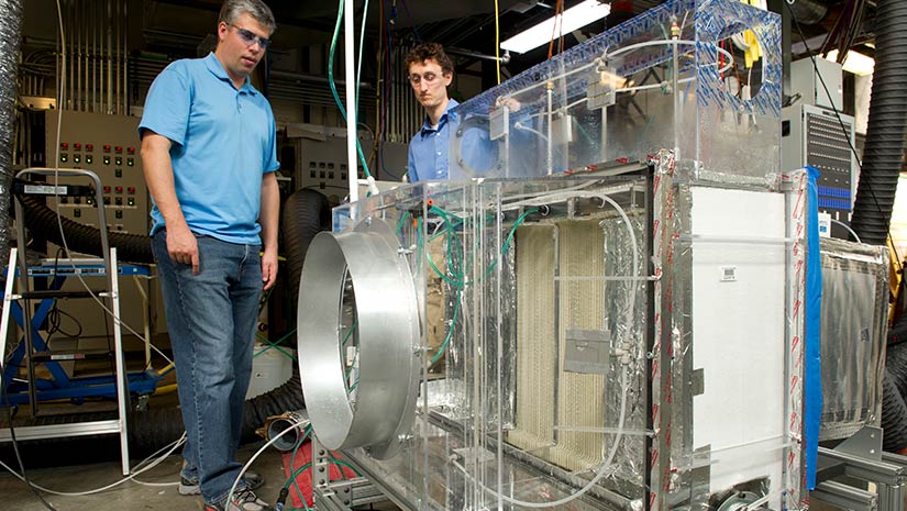Two men looking at a prototype HVAC system.