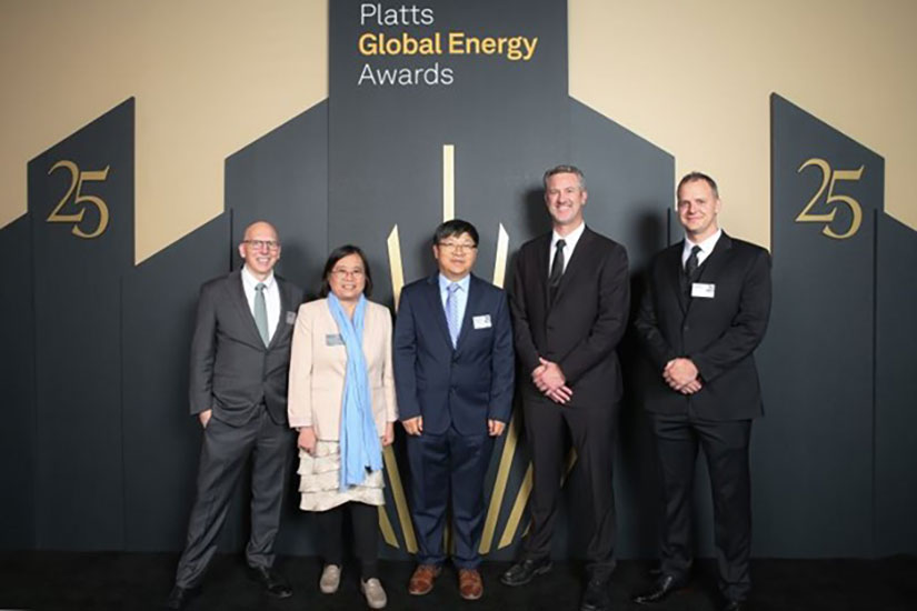 Five people in business formal attire posing for a photo in front of a sign that says, “Platts Global Energy Awards”