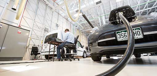 An intern works on an experiment at the Vehicle Testing and Integration Facility 