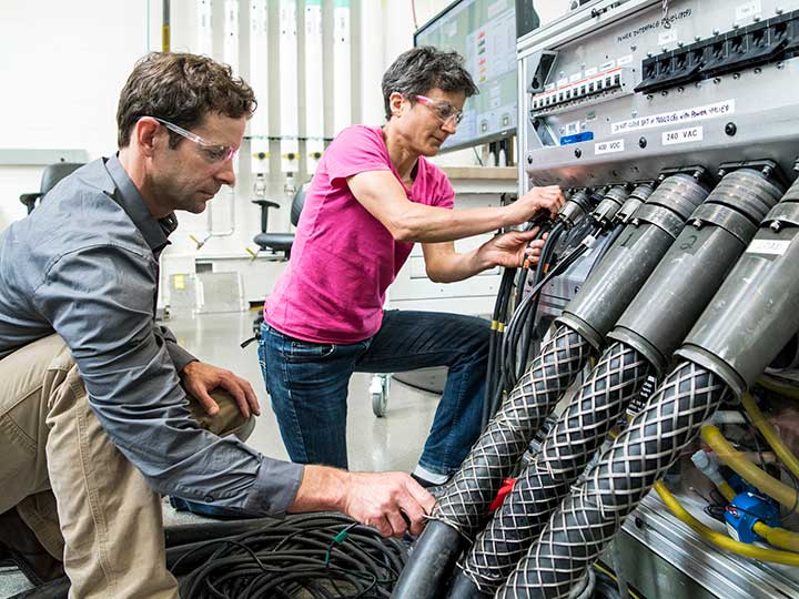 NREL researchers work on the Consolidated Utility Base Energy (CUBE) System in the Energy Systems Integration Facility at NREL.