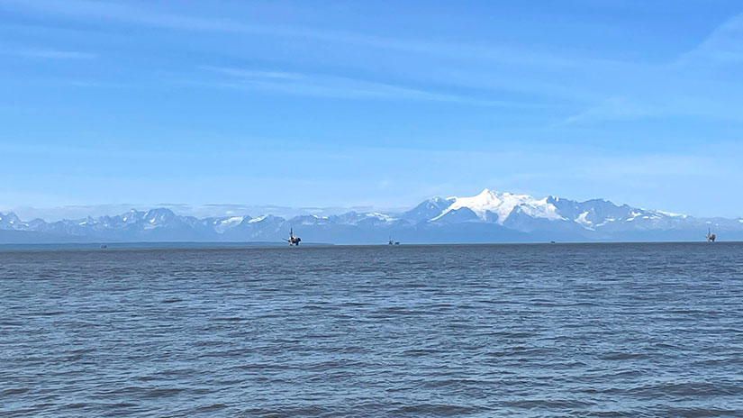 View of inlet water in Alaska with wind turbines in distance